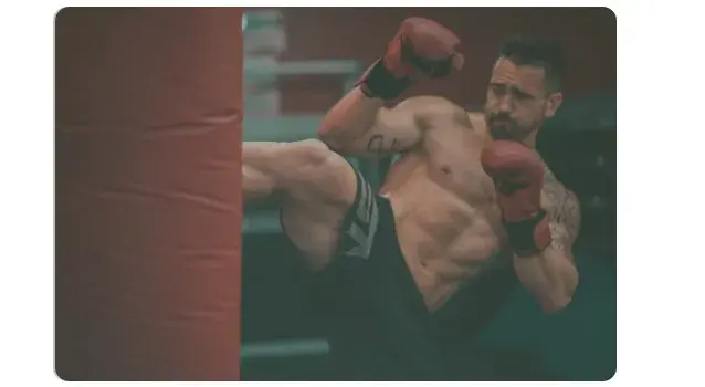 Homme donnant un coup de pied dans un sac de boxe