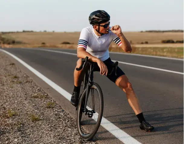 Cycliste arr&ecirc;t&eacute; sur le bas-c&ocirc;t&eacute; d'une route